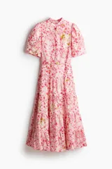 Vestido largo de algodón color rosa con estampado floral, cuello mao, mangas globo cortas, cinturón fino extraíble y falda acampanada con fruncido escalonado.