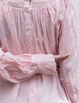 Blusa rosa claro de algodón con escote cuadrado, manga larga y bordado floral en el frente y las mangas.