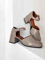 Zapato de cuero vacuno color negro con textura croco, con talón cubierto, pulsera con hebilla y taco de madera forrado en cuero.