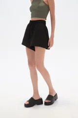 Short negro con textura arrugada, cintura elástica con cordón ajustable y corte holgado.