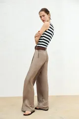 Camiseta sin mangas a rayas horizontales blancas y negras, con cuello barco y corte ajustado.
