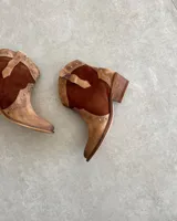 Bota corta de cuero vacuno color negro, con punta fina y tachas plateadas.