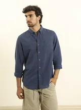 Camisa azul marino de lino y algodón, con cuello abotonado, manga larga con puños enrollados, bolsillo de parche en el pecho y cierre frontal con botones.