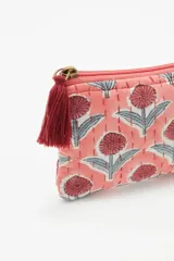 Bolso mini rectangular color salmón con estampado de flores rojas y grises, pespuntes bordados a mano y cierre con tirante decorativo en hilo.