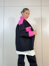 Sobre camisa negra con canesú, bolsillo y puños en color fucsia.