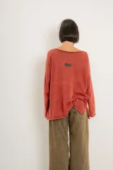 Buzo verde militar de tejido liviano con acabado gastado, corte oversize, cuello bote y mangas largas con hombro caído.