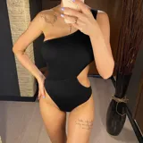 Traje de baño enterizo negro con un solo hombro y abertura en la cintura.
