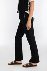 Pantalón negro de corte recto confeccionado en gamuza. Presenta un cierre metálico lateral, tajos en los ruedos y cintura con elástico interior.