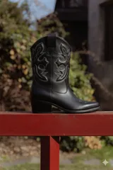 Bota texana baja de cuero negro con bordados decorativos en la caña y taco de madera.