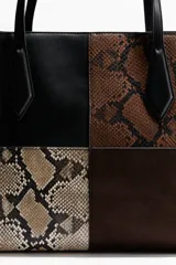 Bolso tipo shopper de gran tamaño con diseño patchwork en cuatro bloques. Presenta paneles en cuero negro liso, cuero con estampado de serpiente marrón oscuro, cuero con estampado de serpiente beige y gamuza marrón oscuro en la base. Tiene dos asas largas de cuero negro y un cierre superior.