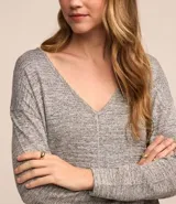 Blusa gris de viscosa texturizada, con mangas largas y escote en pico.