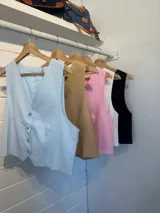 Chaleco rosado con botones, sin mangas y escote en V.