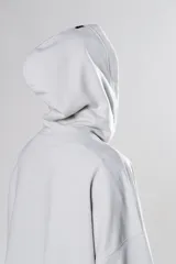 Hoodie gris claro de corte cropped, con capucha y cordones negros con texto blanco.