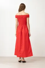 Vestido midi rojo con escote bardot, corte recto y bolsillos laterales.