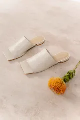 Sandalias de cuero vacuno color negro, con punta cuadrada y capellada amplia que cubre el empeine. Tiene taco bajo de 1 cm.