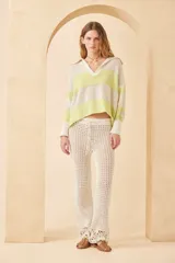 Sweater de punto a rayas horizontales color crema y azul marino, con cuello polo blanco y mangas largas. Tejido de algodón calado.