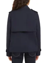 Gabardina corta azul marino de Tommy Hilfiger, con botonadura simple, cuello inglés, trabillas en los hombros, solapa de protección delantera y trasera, puños con tira y botón, y logo metálico en el puño.