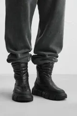 Bota corta color verde militar con diseño acolchado, tirador trasero y suela track negra.