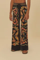 Pantalón de corte amplio con estampado de cachemir en tonos naranja, marrón y celeste sobre fondo negro. Presenta cintura elástica con cordón ajustable.
