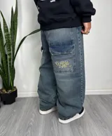 Pantalón de jean celeste de corte ancho con bolsillos laterales y bordado en uno de ellos.