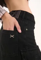 Bermuda de denim azul de tiro bajo, con múltiples bolsillos cargo en los laterales y terminación de ruedo deshilachada.