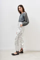 Pantalón plateado metalizado de corte holgado con bolsillos laterales y lazo en la cintura.