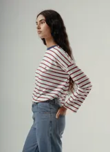 Camiseta de manga larga, corte holgado, con cuello redondo y estampado de rayas horizontales en tonos negro y marrón.