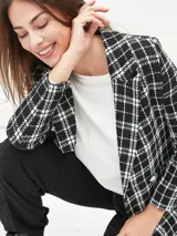 Blazer negro con estampado a cuadros blancos, doble botonadura y solapas de muesca.
