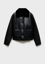 Chaqueta corta negra de cuero sintético con cuello y puños de piel sintética. Cierre frontal con botones y bolsillos de parche.