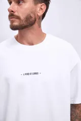 Remera blanca de corte holgado con estampado pequeño con texto en el frente.