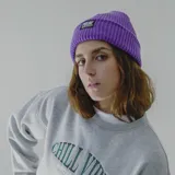 Gorro de lana blanco con etiqueta negra con el logo de la marca Pulau.