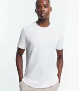 Remera blanca de corte regular, confeccionada en media malla con textura diferenciada. Tiene cuello redondo y mangas cortas.