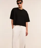 Pantalón wide leg de helanca color blanco, con cintura elástica ajustable con cordón, bolsillos laterales, raya lateral negra y bajo ajustable.
