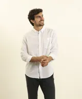 Camisa azul marino de lino y algodón, con cuello abotonado, manga larga con puños enrollados, bolsillo de parche en el pecho y cierre frontal con botones.