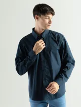 Camisa azul marino de manga larga con cuello abotonado y corte clásico.