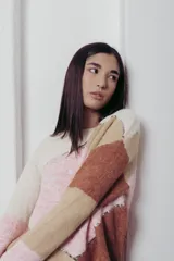 Suéter de punto con diseño geométrico en tonos rosa, beige y marrón, con detalles de lentejuelas.