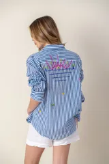 Camisa blanca de manga larga con bordados de motivos playeros.