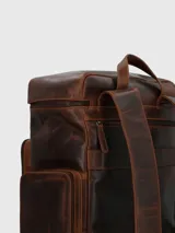 Mochila de cuero marrón con múltiples bolsillos con cierre y correas ajustables.