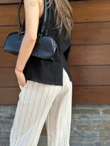 Pantalón de vestir color beige con finas rayas verticales negras, de corte recto y tiro alto.
