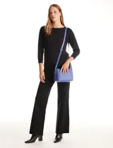 Cartera bandolera Tahari modelo Cooper, color azul, confeccionada en ecocuero con textura granulada. Cuenta con asa larga regulable, compartimento principal con cierre, bolsillos internos y un monedero extra con cierre.