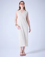 Vestido largo color crema, tejido con hilos metalizados, de corte recto, sin mangas y con cuello en V.