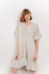 Vestido corto color beige confeccionado en algodón, con escote en V con detalles bordados, mangas cortas amplias con volados y falda con ruedo en volado.