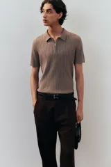 Pantalón marrón de corte amplio, confeccionado en mezcla de lino y algodón. Cuenta con cierre frontal con botón y corchete ocultos, bolsillos laterales ribeteados y bolsillos traseros insertados con botón.