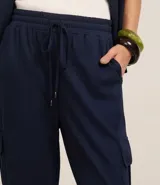 Pantalón largo color verde oliva, de corte pijama, confeccionado en malla orly. Presenta cintura elástica con lazo, bolsillos laterales tipo cargo y corte fluido.