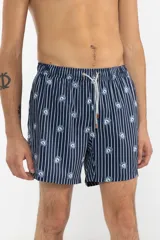 Short de baño azul marino con rayas verticales blancas y estampado de flores azules. Cuenta con cintura elástica con cordón regulable, bolsillos laterales y bolsillo trasero con cierre.