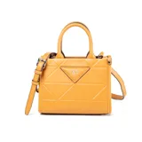 Cartera pequeña color camel de símil cuero con diseño geométrico en relieve. Tiene correa regulable y asas fijas, cierre principal, bolsillo interno con cierre y bolsillo interno abierto. El logo de XL Extra Large está grabado en el frente.