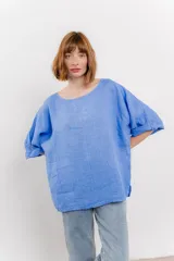 Blusa color beige confeccionada en lino, de corte holgado, mangas 3/4 y cuello redondo.