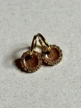 Par de aros dorados con dije circular de resina color terracota con glitter y borde de strass.