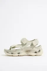 Sandalias deportivas color hueso con tiras de ajuste con velcro y suela track con plataforma.