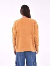 Sweater mostaza de tejido suave con cuello redondo y mangas largas.